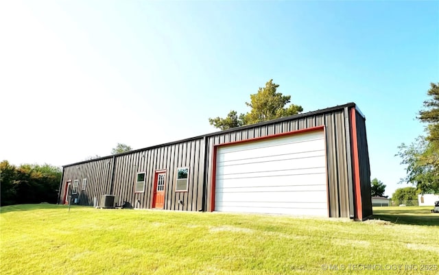 garage featuring central air condition unit and a lawn