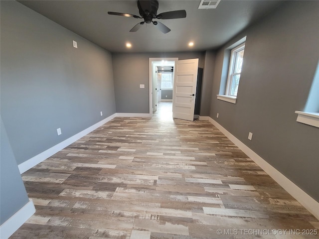 empty room with ceiling fan and light hardwood / wood-style floors