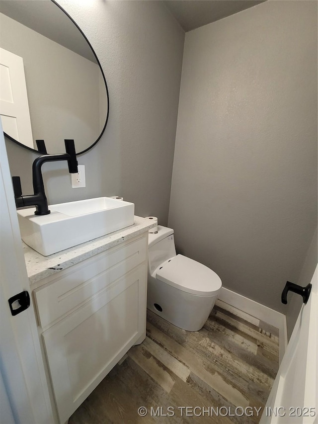 bathroom with toilet, hardwood / wood-style flooring, and vanity