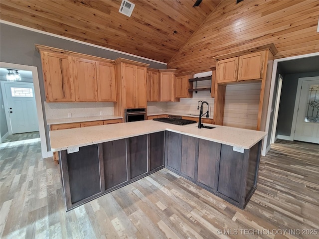 kitchen with wooden ceiling, stainless steel appliances, light hardwood / wood-style floors, and a kitchen island with sink