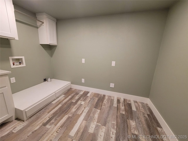 washroom with washer hookup, cabinets, electric dryer hookup, and light hardwood / wood-style floors