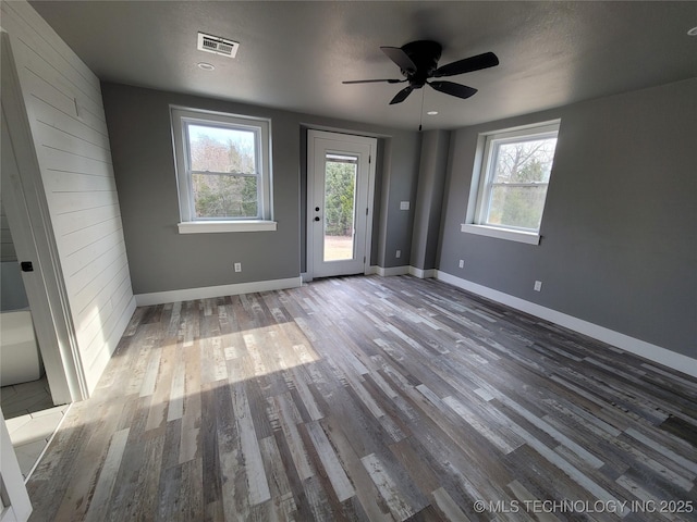 unfurnished room featuring hardwood / wood-style flooring, ceiling fan, and a healthy amount of sunlight