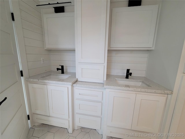 bathroom with vanity, tile patterned flooring, and wooden walls