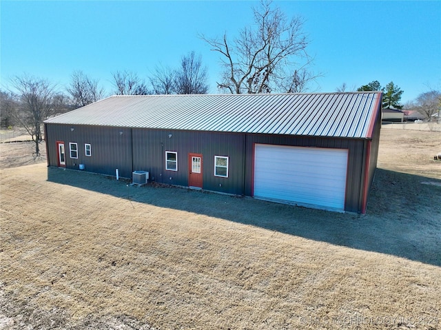 view of front of house featuring central air condition unit, an outdoor structure, and a garage