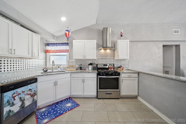 kitchen featuring stainless steel appliances, sink, white cabinetry, wall chimney range hood, and lofted ceiling