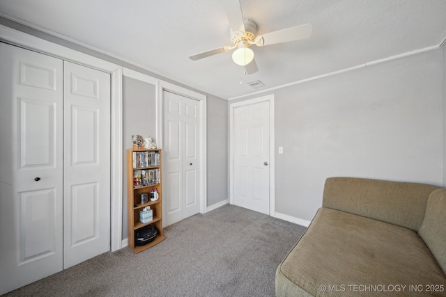 sitting room featuring ceiling fan, carpet, and ornamental molding