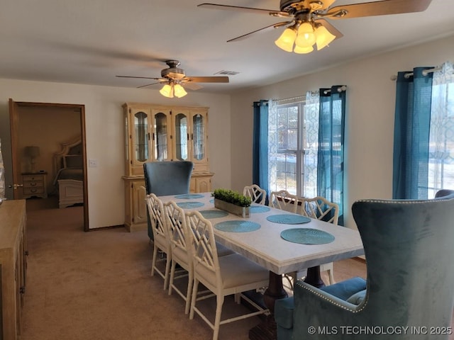 carpeted dining room with ceiling fan