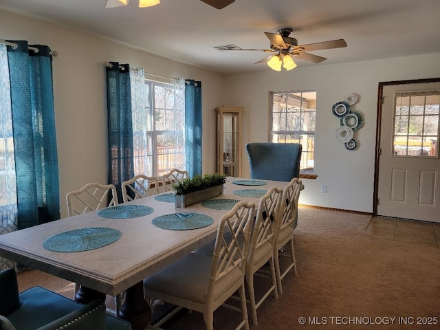 carpeted dining space with ceiling fan