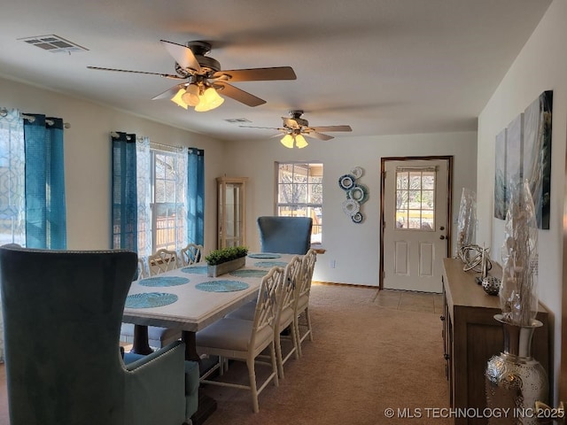 dining room with ceiling fan and light colored carpet