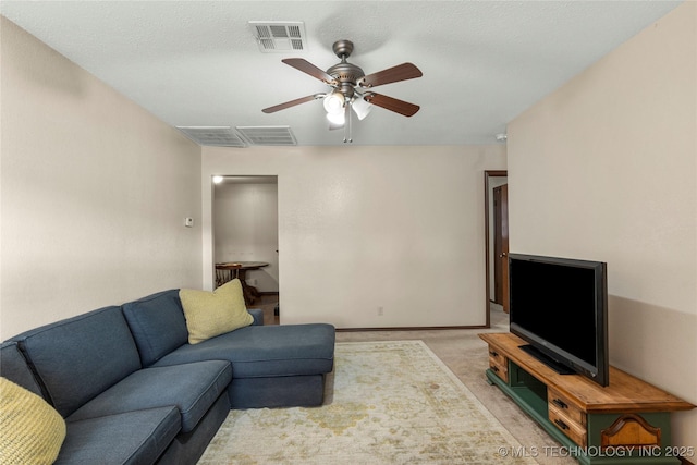 carpeted living room featuring a textured ceiling and ceiling fan