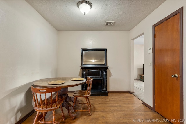 dining area featuring hardwood / wood-style flooring and a textured ceiling