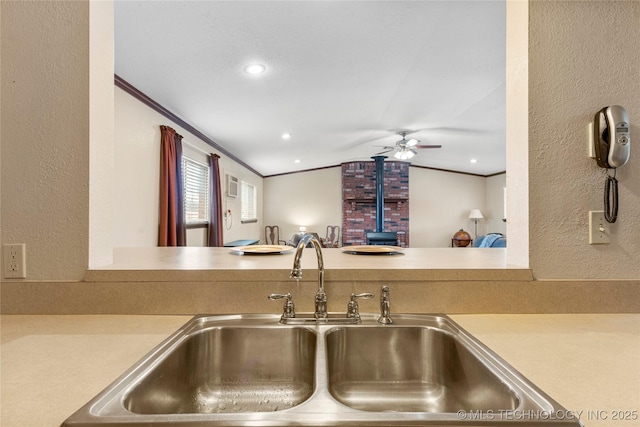 kitchen featuring sink, ornamental molding, and lofted ceiling