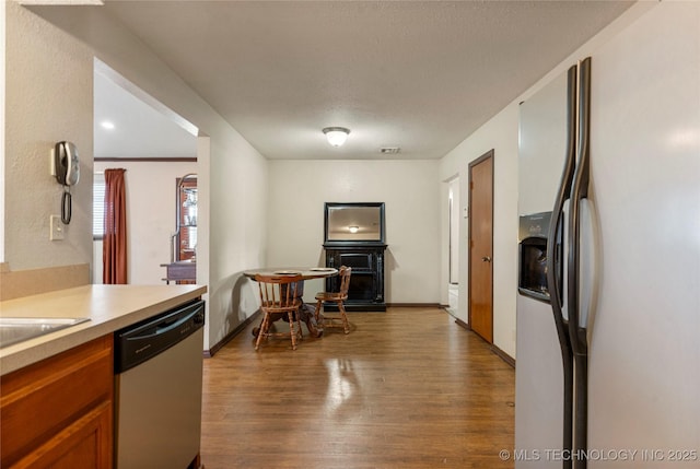 kitchen featuring stainless steel appliances, a textured ceiling, and hardwood / wood-style flooring