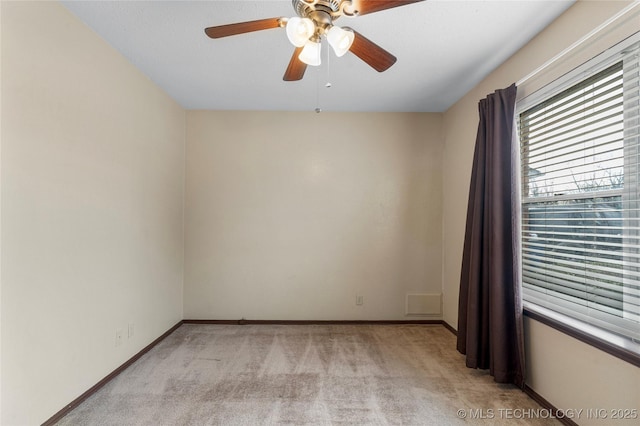 carpeted spare room featuring ceiling fan