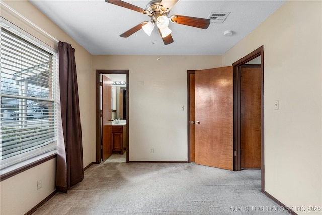 unfurnished bedroom featuring ensuite bath, light carpet, and ceiling fan