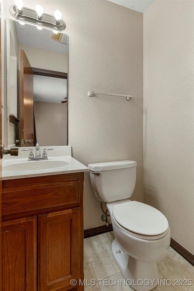 bathroom with toilet, tile patterned floors, and vanity