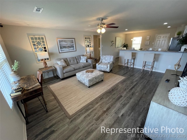 living room featuring dark wood-type flooring and ceiling fan