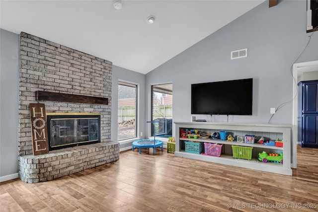 living room with lofted ceiling, wood-type flooring, and a fireplace