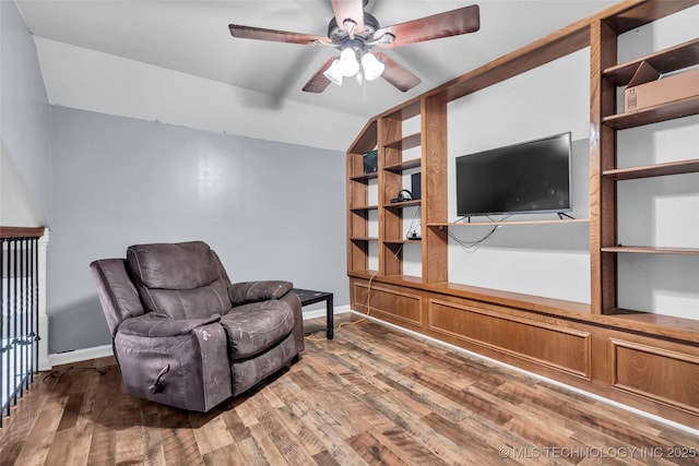 sitting room featuring ceiling fan, vaulted ceiling, built in features, and hardwood / wood-style flooring