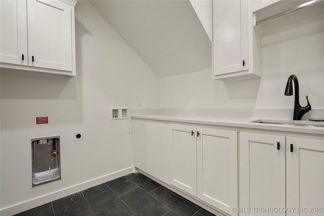 washroom with dark tile patterned flooring, sink, washer hookup, electric dryer hookup, and cabinets