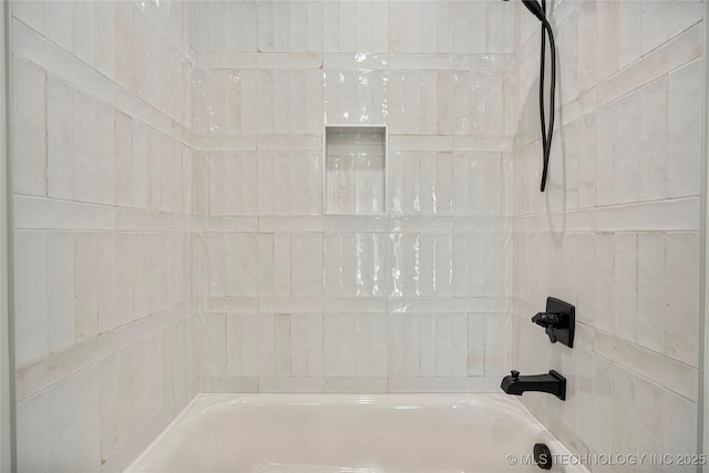 interior details featuring tiled shower / bath combo