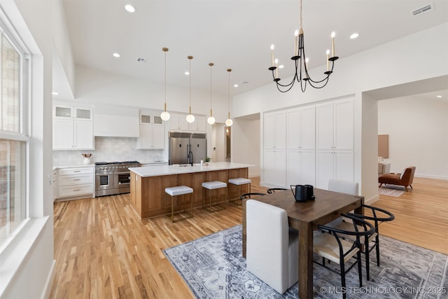 dining area featuring light wood-type flooring and a notable chandelier