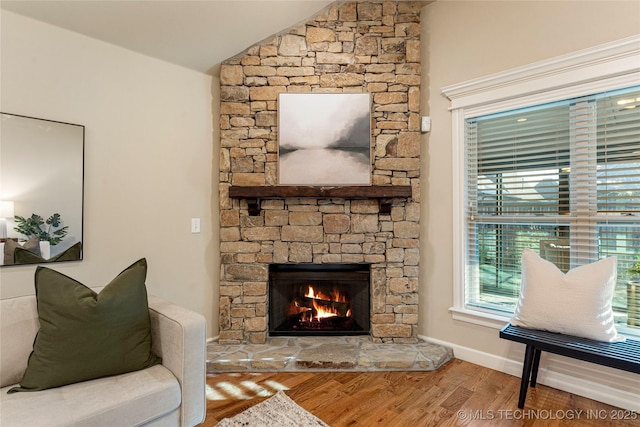 living room with lofted ceiling, a fireplace, and hardwood / wood-style floors