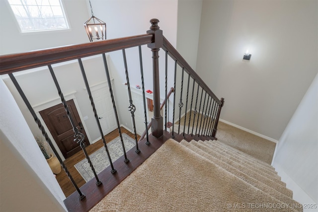 stairway with a notable chandelier