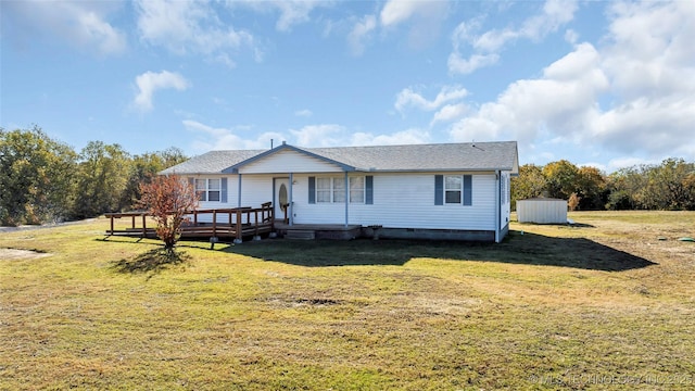 view of front of home with a wooden deck and a front lawn