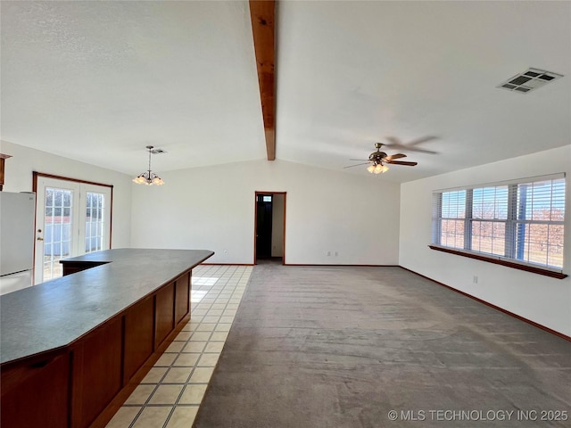 kitchen featuring ceiling fan with notable chandelier, lofted ceiling with beams, pendant lighting, and plenty of natural light