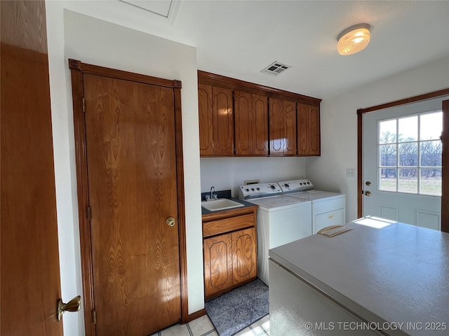 washroom featuring sink, cabinets, washer and clothes dryer, and light tile patterned floors