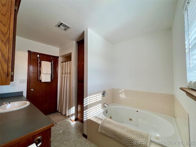 bathroom with tiled bath and vanity