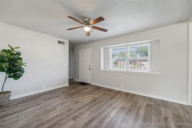 spare room with a textured ceiling, ceiling fan, and wood-type flooring