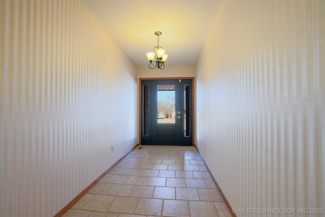 doorway with light tile patterned floors and a chandelier