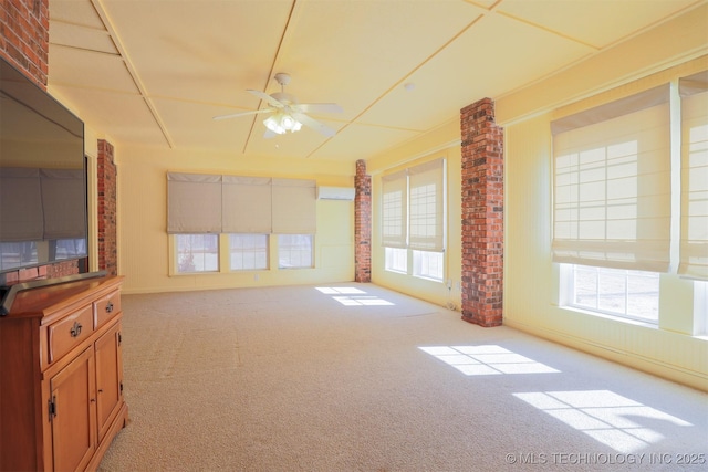 unfurnished living room with light carpet, ceiling fan, and a wall mounted air conditioner