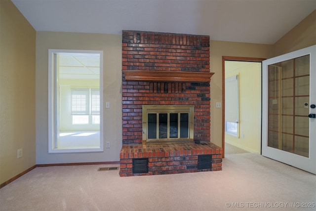 unfurnished living room featuring carpet floors and a brick fireplace