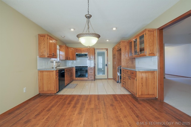 kitchen featuring decorative light fixtures, stainless steel microwave, dishwasher, light stone countertops, and range