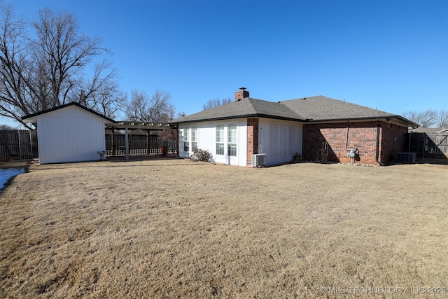 rear view of house featuring a yard and central AC