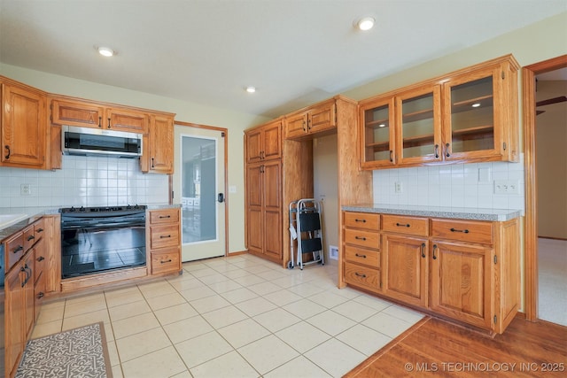 kitchen with light tile patterned flooring, decorative backsplash, and black electric range