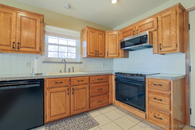 kitchen featuring black appliances, light tile patterned floors, decorative backsplash, and sink