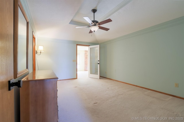 empty room featuring ceiling fan, ornamental molding, lofted ceiling, and light colored carpet