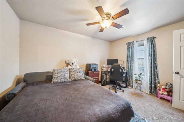 bedroom with ceiling fan, a textured ceiling, and carpet flooring