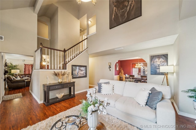 living room featuring high vaulted ceiling, a chandelier, hardwood / wood-style flooring, and beamed ceiling