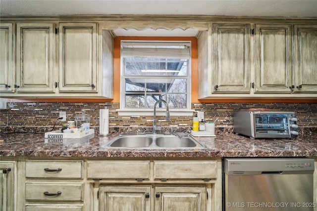 kitchen with dark stone counters, stainless steel dishwasher, tasteful backsplash, and sink