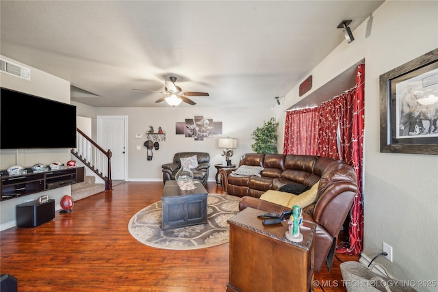 living room with ceiling fan and dark wood-type flooring