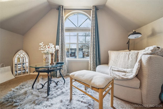 sitting room featuring carpet and vaulted ceiling