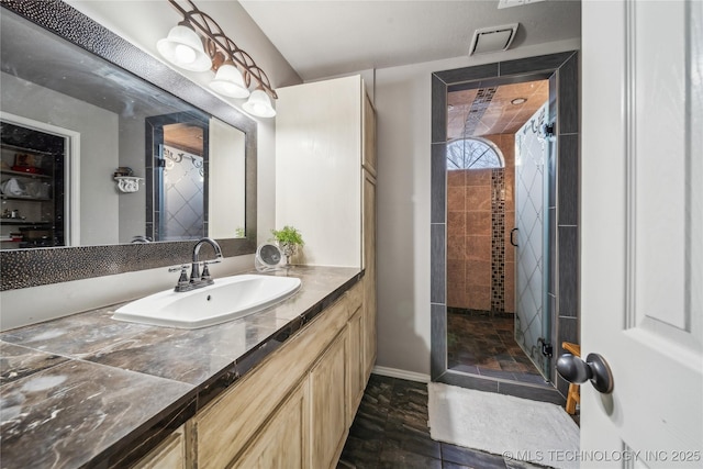 bathroom with a shower with door and vanity