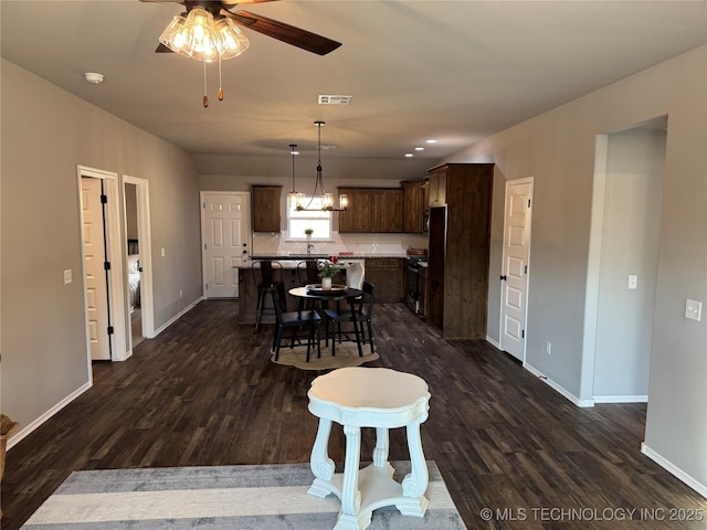 dining area with ceiling fan and dark hardwood / wood-style flooring