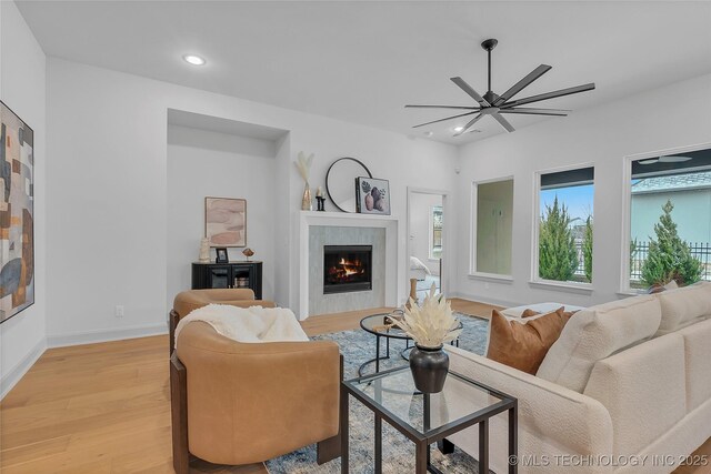 living room with light wood-type flooring and ceiling fan