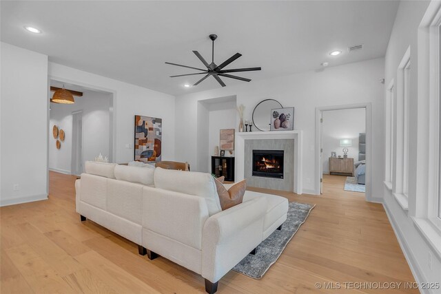 living room with light wood-type flooring and ceiling fan